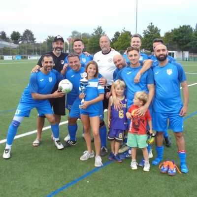 Eine Mannschaft steht auf dem Fu&szlig;ballplatz. Sie haben das Turnier gewonnen.