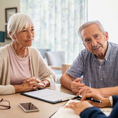 Ein Mann und eine Frau sprechen mit einer anderen Frau &uuml;ber Geld. 