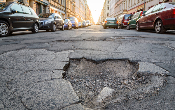 Eine Stra&szlig;e mit Loch. Das Loch ist im Asphalt. 