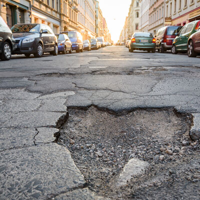 Eine Stra&szlig;e mit Loch. Das Loch ist im Asphalt. 