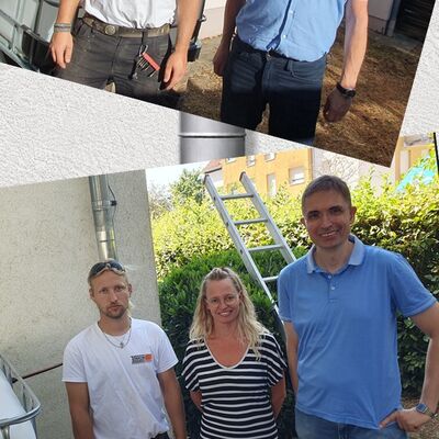 Auf dem Bild stehen oben zwei M&auml;nner nebeneinander. Und stehen zwei M&auml;nner und eine Frau. Im Hintergrund ist ein Rohr zu sehen, mit dem Wasser f&uuml;r das Gie&szlig;en gesammelt wird. 