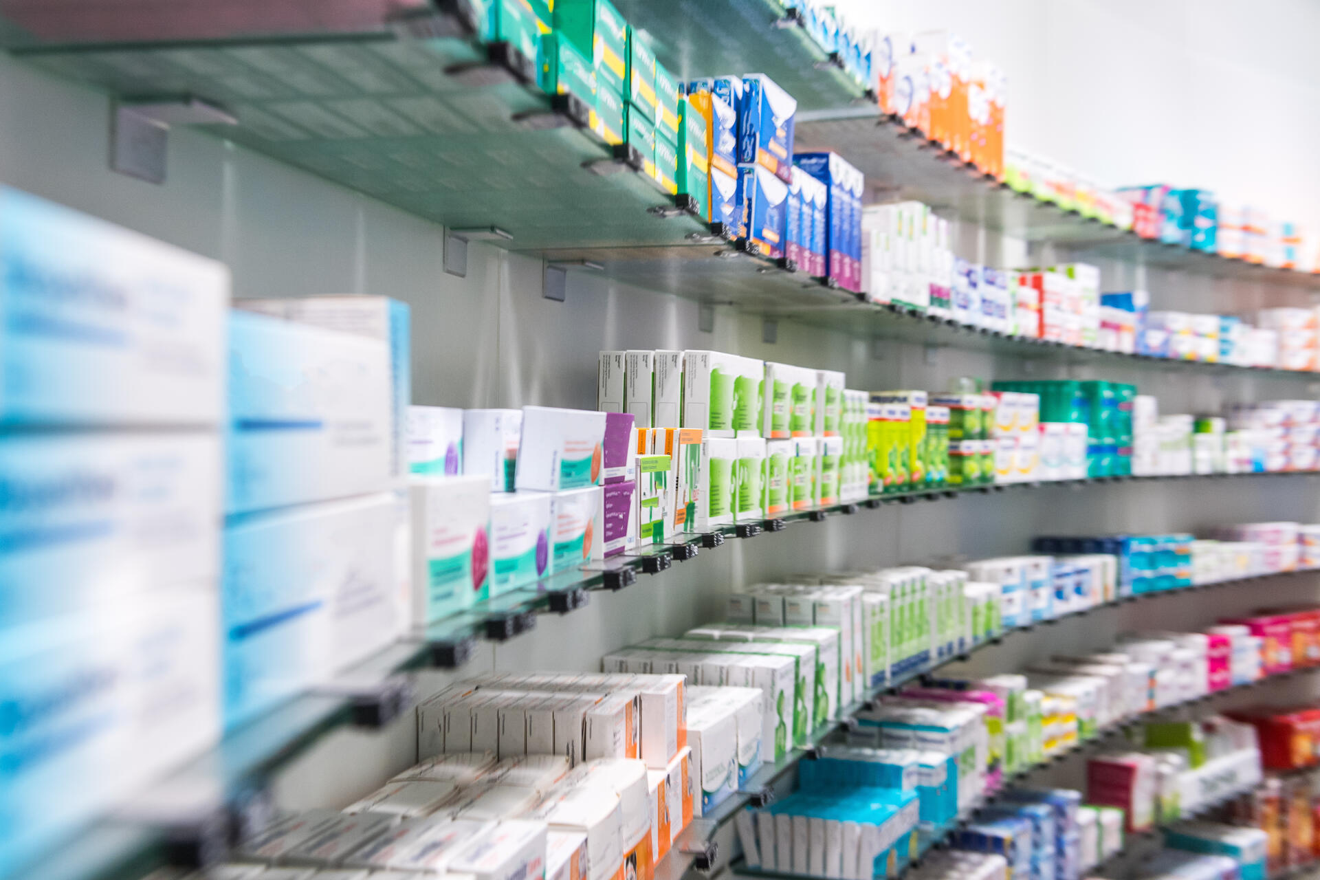 In einer Apotheke stehen viele Medikamente in Regalen.